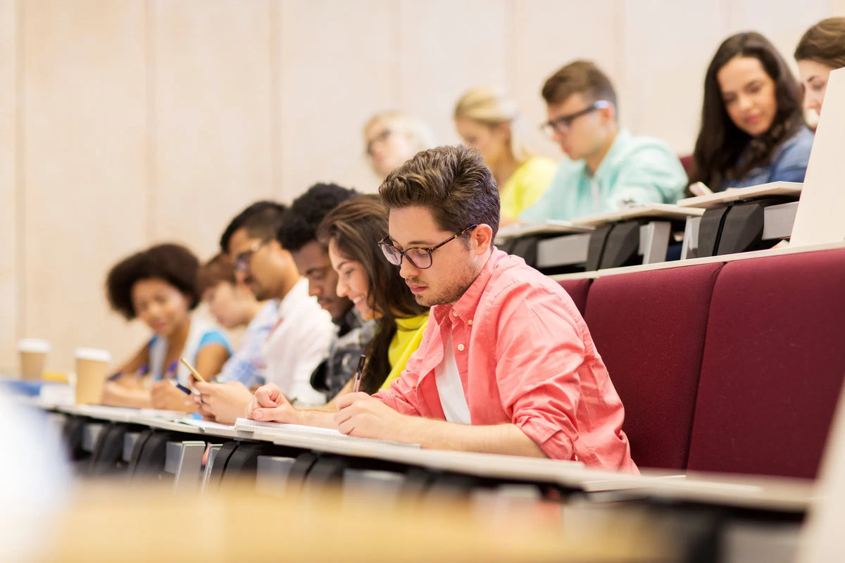 Estudiantes tomando notas en un auditorio universitario