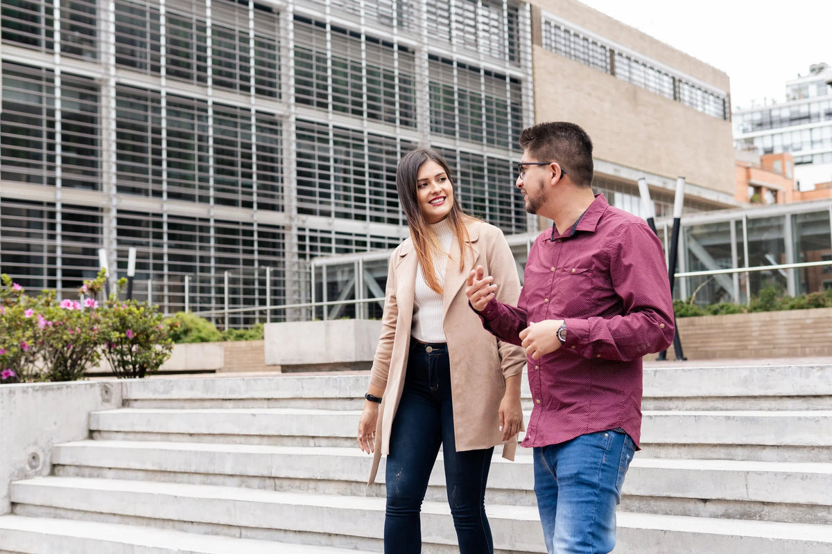 Dos profesionistas conversando frente a un edificio